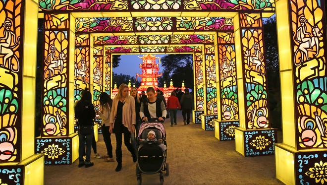 People walk under a series of illuminated arches at the monkey gallery to enter the China Lights display last year at Boerner Botanical Gardens.
